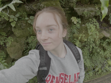 Clare smiling in an arboretum. 